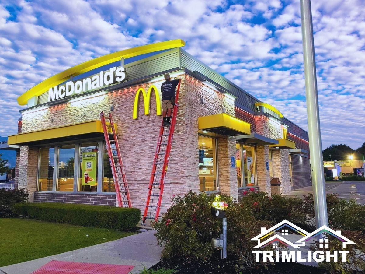 Permanent lighting being installed on a fast-food restaurant roofline