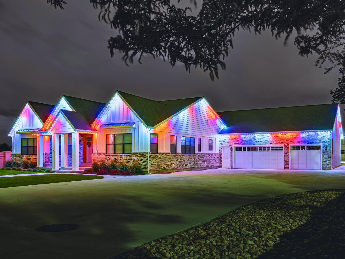 Multicolor permanent outdoor lights on a white modern farmhouse