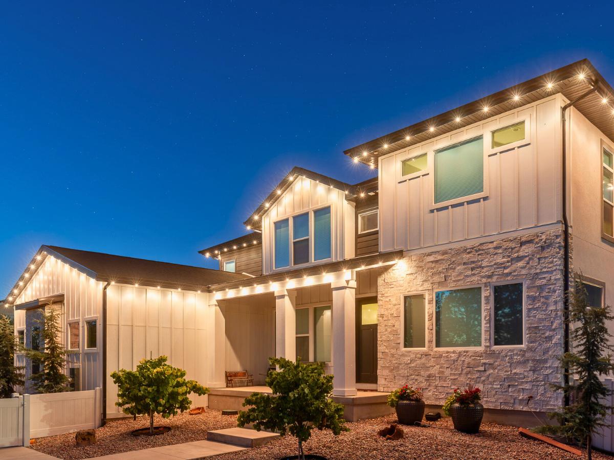 Warm white permanent roofline lights on a two-story farmhouse